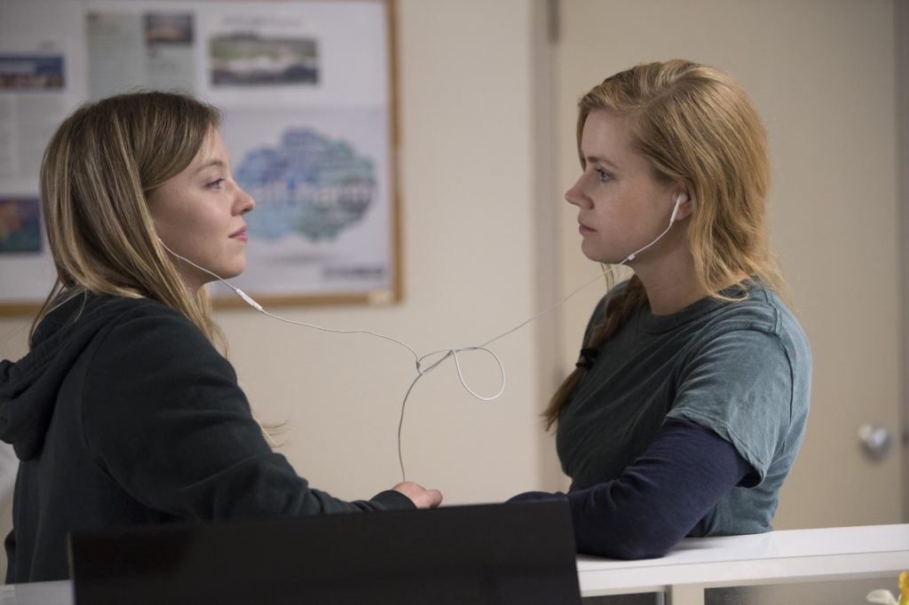 Sharp Objects's Sydney Sweeney (Alice) and Amy Adams (Camille Preaker) share headphones. Photo credit: Anne Marie Fox/HBO